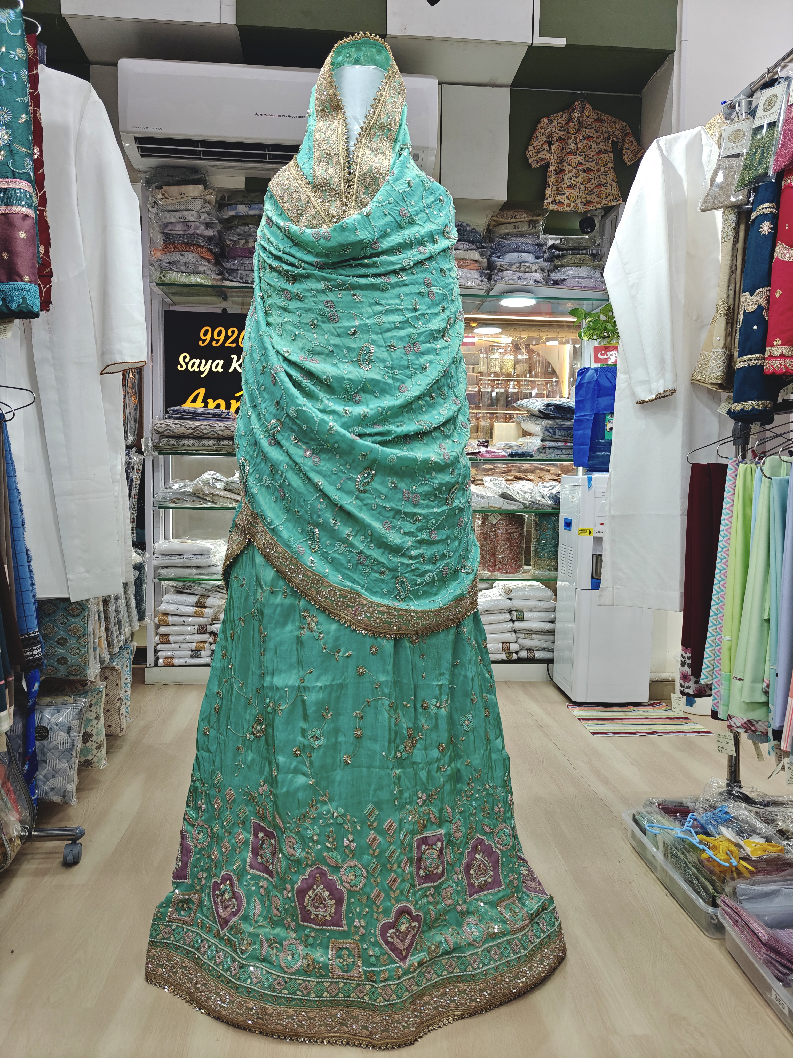  Rs 12500 Teal Dulhan Bridal Jori in rich blue green fabric with golden embroidery, Ghagra has delicate floral ornamental motifs, heavily embroidered traditional patterns, geometric details, contrasting deep plum mauve accents 